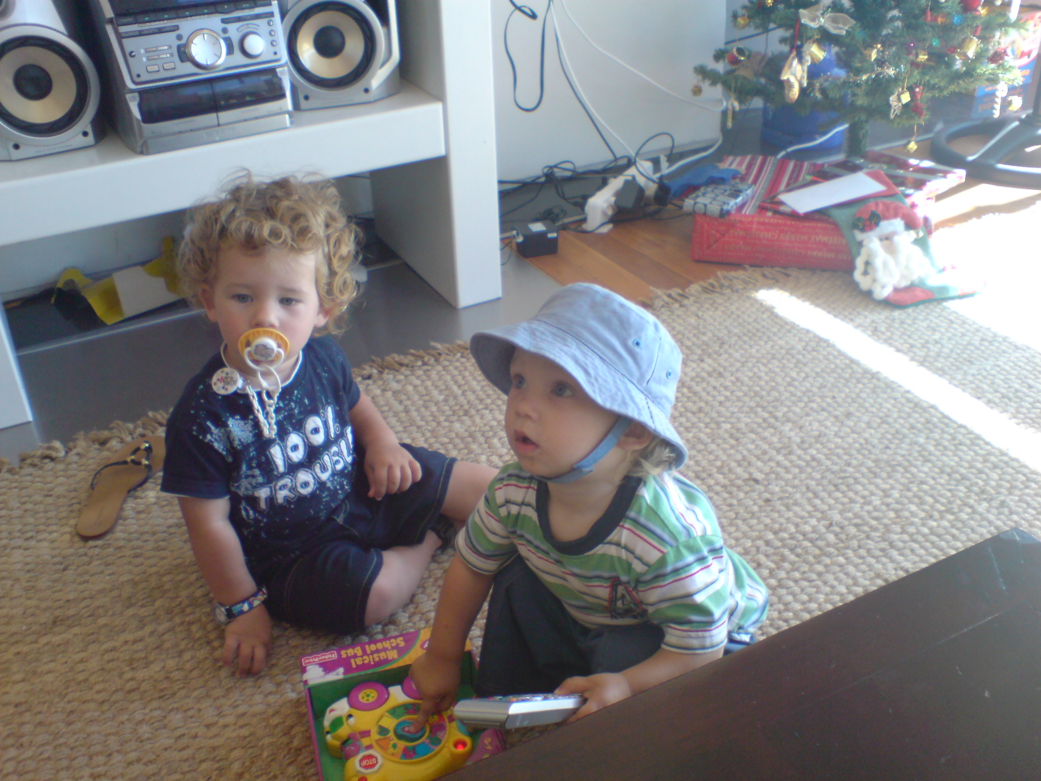 Robert multitasking with toy and remote while Mr. (100% Trouble) is quietly watching